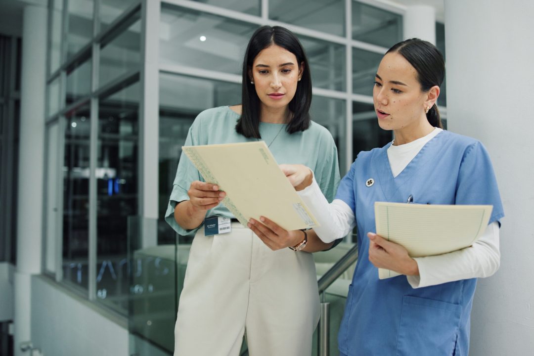 Team, documents and nurse or women in hospital for ward clerk, icu emergency and medical records at night. Healthcare administration, surgery schedule and discussion with people for overtime.